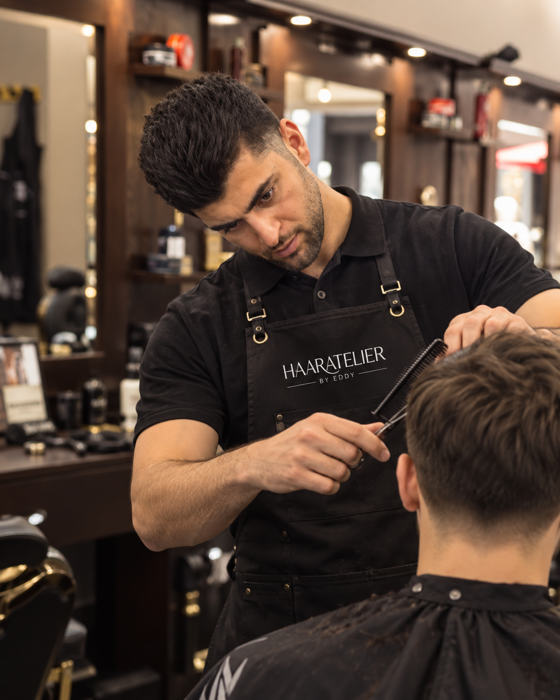 Amran schneidet einem Kunden die Haare